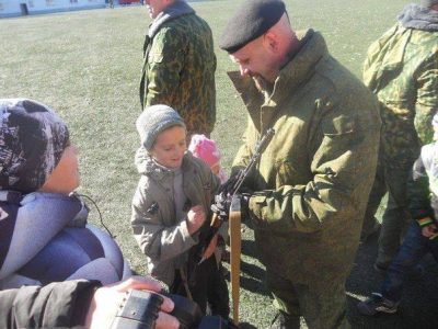 Главарь алчевской банды показывает детям оружие Главарь алчевской банды показывает детям оружие
