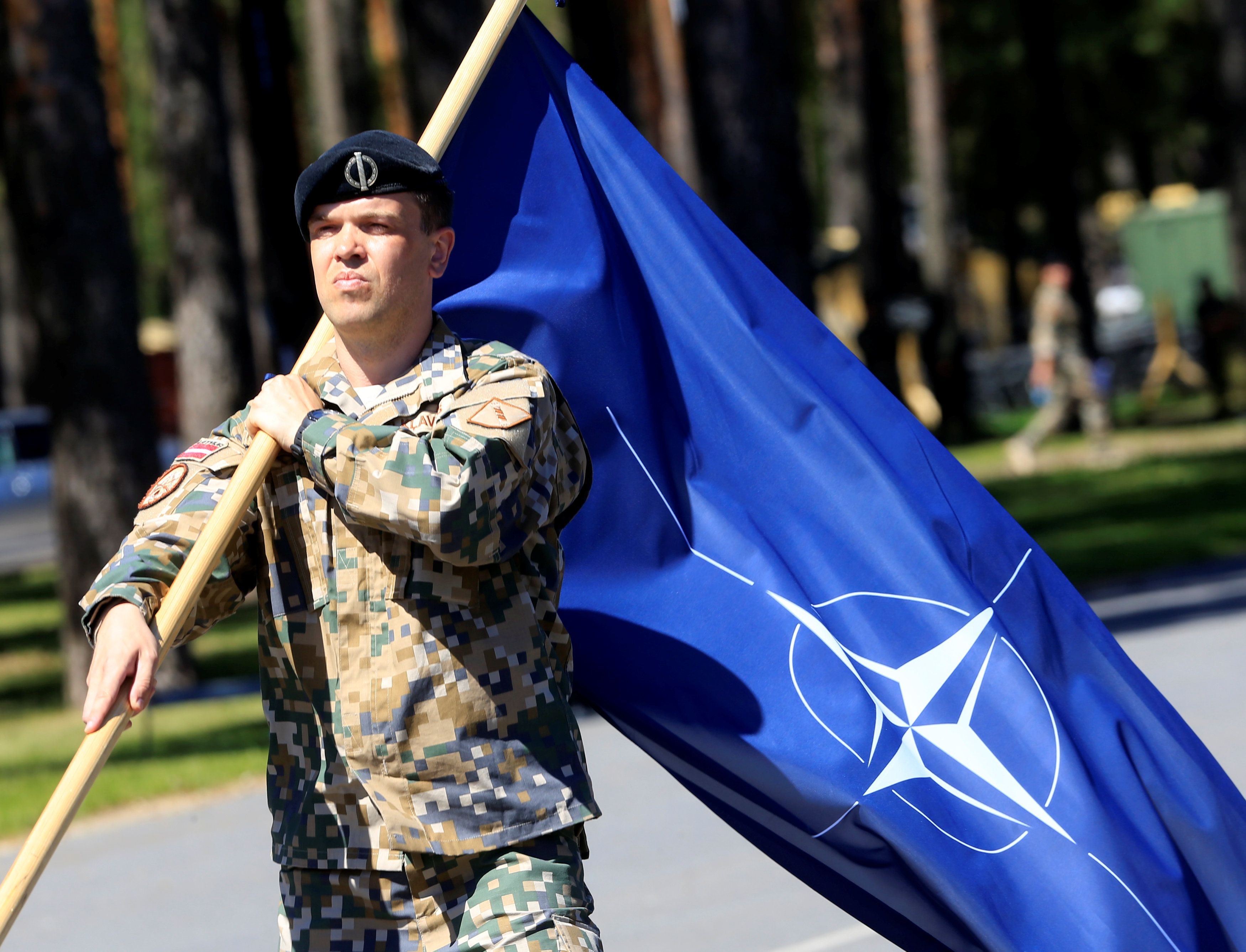 Новости россии и нато сегодня. Флаг НАТО. Ромелашвили НАТО. Флажок НАТО. Солдат с флагом.