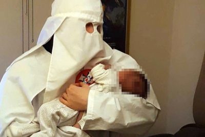 Адам Томас позирует с маленьким Адольфом на руках в робе ку-клукс-клана / Фото: West Midlands Police Адам Томас позирует с маленьким Адольфом на руках в робе ку-клукс-клана / Фото: West Midlands Police