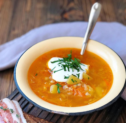 Суп капустняк с рисом очень хорошо сочетается со сметаной и зеленью - Капустняк рецепт