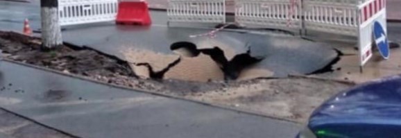 Асфальт устал: в центре Киева на дороге из-за ливня зазияла громадная дыра - фото