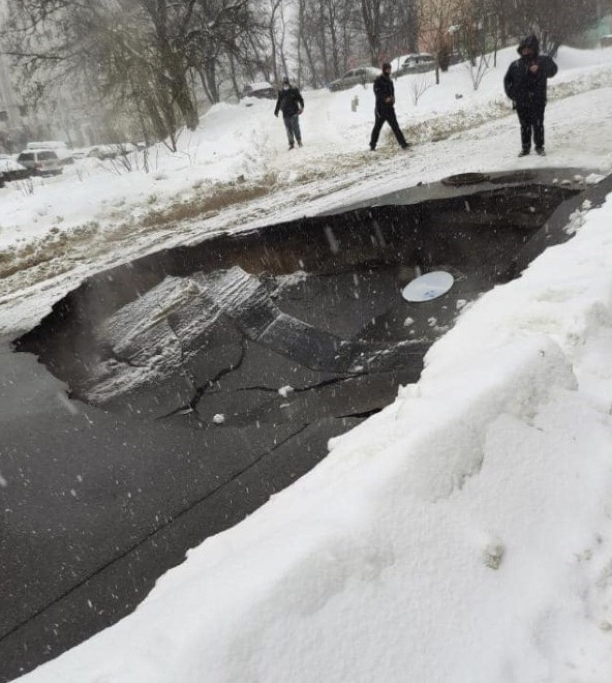 В Киеве снег проломил гигантскую яму в асфальте на дороге