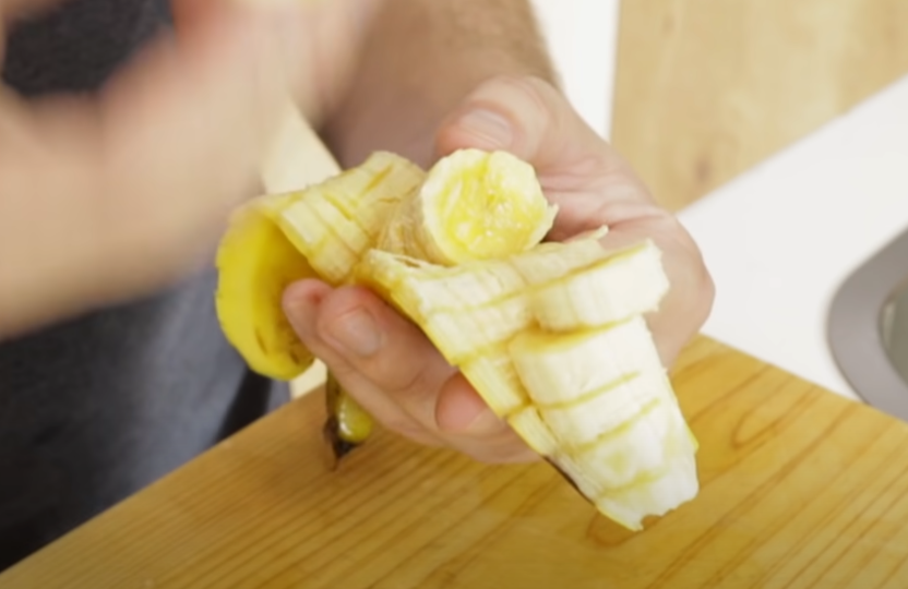 Чоловік нарізав банан за допомогою голки Чоловік нарізав банан за допомогою голки